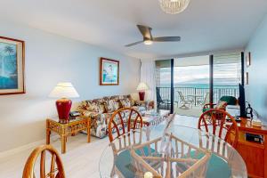 un salon avec une table en verre et des chaises dans l'établissement Kahana Reef 413, à Kahana