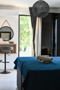 a bedroom with a blue bed and a table and a mirror at Apartmani Vito in Biograd na Moru