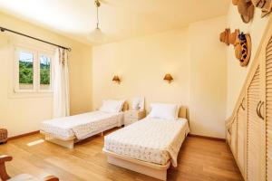 una camera da letto con due letti e una finestra di Villa Barbaro by Villa Plus ad Ágios Stéfanos Altre 19 foto
