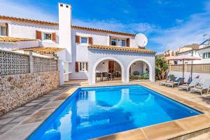 a villa with a swimming pool in front of a house at Villa Monsy 2 in El Port