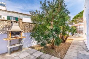 a outdoor grill with a tree in front of a building at Villa Monsy 2 in El Port