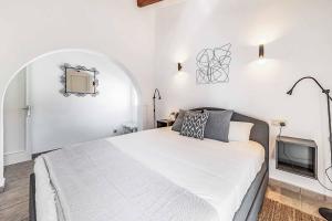 a white bedroom with a bed and a tv at Villa Monsy 2 in El Port +17 photos
