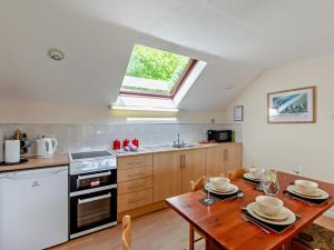 a kitchen with a table and a stove and a window at 2 Bed in Amroth 94789 in Pembrokeshire +18 photos