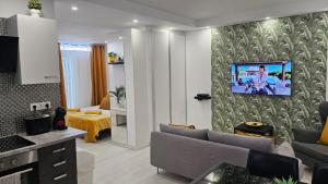 a living room with a couch and a tv on a wall at Papagayo Beach Apartments in Arona
