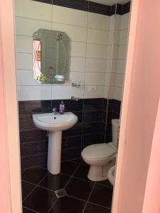 a bathroom with a sink and a toilet at A 3-floor building with 4 bedroom near beach in Fier +33 photos