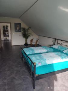 a bedroom with two beds and a potted plant at Ferienwohnung Jessica in Mastershausen