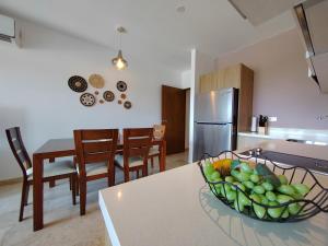 a kitchen with a bowl of fruit on a table at IPANA Luxury Apartments by Vacaciones.Yeah in Playa del Carmen +147 photos