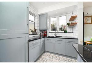 奧平頓的住宿－lovely 2BR house in Orpington，厨房配有白色橱柜和水槽