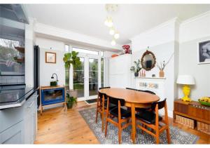 - une salle à manger avec une table et des chaises en bois dans l'établissement lovely 2BR house in Orpington, à Orpington