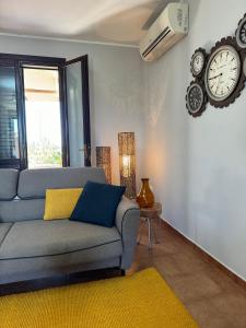 een woonkamer met een bank en een klok aan de muur bij Casa Vacanze Zenith in Marsala