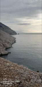 a large body of water with a rocky shore at PLOMIN SKY&BAY in Plomin