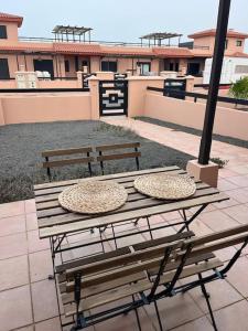 einem Picknicktisch und Bänken auf einem Gebäude in der Unterkunft relax in Majanicho