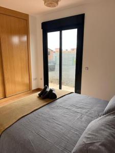 ein Schlafzimmer mit einem großen Bett mit einem großen Fenster in der Unterkunft relax in Majanicho