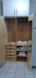 uma cozinha com um armário com toalhas brancas em Flat Vista Mar em Boa Viagem em Recife