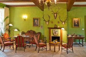 a living room with green walls and chairs and a fireplace at Romantik Hotel Gutshaus Ludorf in Ludorf