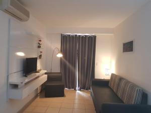 - un salon avec un canapé et une télévision dans l'établissement Apartamento Giardino Rio Quente, à Rio Quente