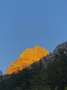 una montaña rocosa con un cielo azul en el fondo en Guesthouse Rexhepi, en Kolgecaj