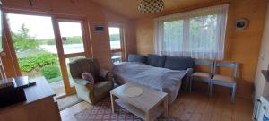 a living room with a couch and a table at Lemanka Domek Letniskowy in Gowidlino