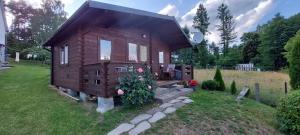 a small house with flowers in front of it at Lemanka Domek Letniskowy in Gowidlino