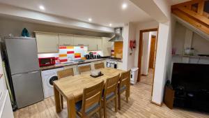 uma cozinha com uma mesa e cadeiras e um frigorífico em Lodge Nine - A Beautiful Holiday Home in Devon em Chudleigh