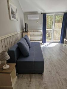 salon z niebieską kanapą i balkonem w obiekcie Leśny zakątek w mieście Radzyń