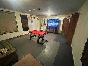 Habitación con mesa de ping pong y TV. en Intihuatana Hostel en Pisac
