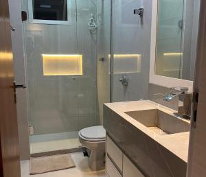 a bathroom with a shower and a toilet and a sink at Apartamento Renovado na beira da Praia in Vila Velha