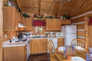 cocina con armarios de madera, mesa y nevera en A Postcard View, en Pigeon Forge 21 fotos más