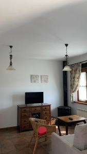 a living room with a tv and a table at Apartamentos El Picoretu in Mestas de Con