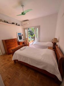sypialnia z 2 łóżkami, komodą i telewizorem w obiekcie Charmosa casa 4 suítes no Jd Europa w São Paulo