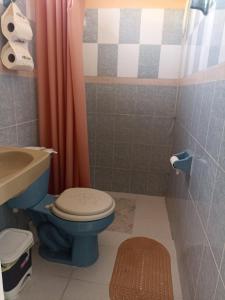 een badkamer met een blauw toilet en een wastafel bij Casa Chero in Comalcalco