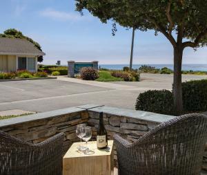 a bottle of wine sitting on a table with two glasses at Fireside Inn on Moonstone Beach in Cambria