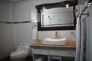 uma casa de banho com um lavatório, um WC e um espelho. em InkaOcean Hotel em Ilo