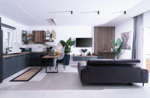 Una cocina y una sala de estar con un sofá y una mesa. en Iceberg Suite with Jacuzzi, en Kalamaki