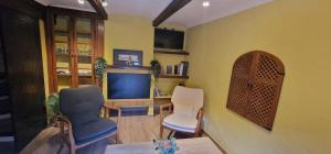 a living room with two chairs and a tv at La Torre Del Angel Casa Rural in Mirambel