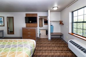 une chambre d'hôtel avec un lit et une chambre avec un bureau dans l'établissement Extended Stay Airport, à Green Bay