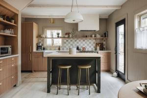 a kitchen with a black island with two bar stools at Townie 4 - The Fern in Union Pier
