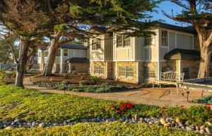 a house with trees and flowers in front of it at Fogcatcher Inn in Cambria