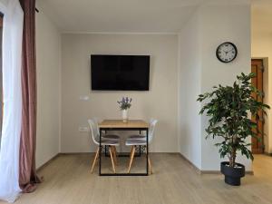 a dining room with a table and chairs and a clock at House Angelina in Kruševo