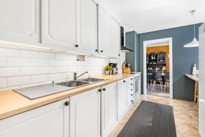 a kitchen with white cabinets and a sink at Engbu in Vågbø