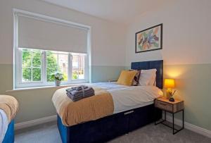 a bedroom with a large bed with a window at The Sycamores Country Escape in Marthall