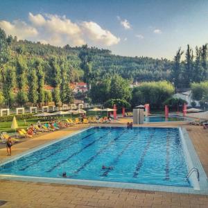 a large swimming pool with people sitting around it at Pousada de Marvao in Marvão