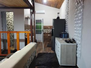 a room with a kitchen with a counter and a refrigerator at Casa inteira Chale e Edicula in Itanhaém