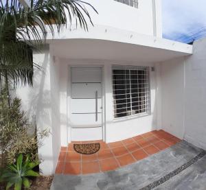 a front door of a white house with a palm tree at La Placita in Cordoba