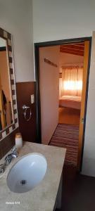 a bathroom with a sink and a room with a bed at La Placita in Cordoba
