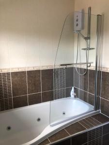 a bath tub with a glass enclosure in a bathroom at Well presented 3 Bed House- 9 Guests - Great for Leisure stays or Contractors -NG8 postcode in Nottingham