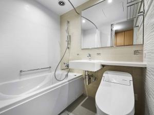 y baño con aseo blanco y lavamanos. en Daiwa Roynet Hotel Wakayama, en Wakayama