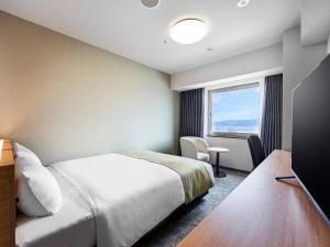 a hotel room with a bed and a window at Daiwa Roynet Hotel Wakayama in Wakayama
