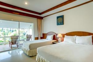 a hotel room with two beds and a balcony at Neptune's Villa in Haad Rin