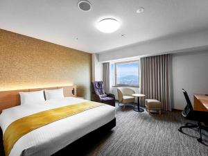 a hotel room with a bed and a desk and a window at Daiwa Roynet Hotel Wakayama in Wakayama